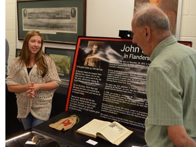 Grade 11 WDHS student Elizabeth Longley explains her John McCrae exhibit to visitors at the shool's museum.  Photo originally published for the Flamborough Review.  Credit Mac Christie