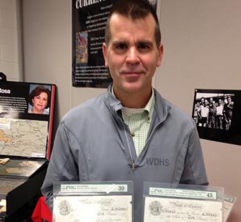 History teacher Rob Flosman with currency from Operation Bernhard. Photo by Abigail Cukier, published in The Canadian Jewish News.